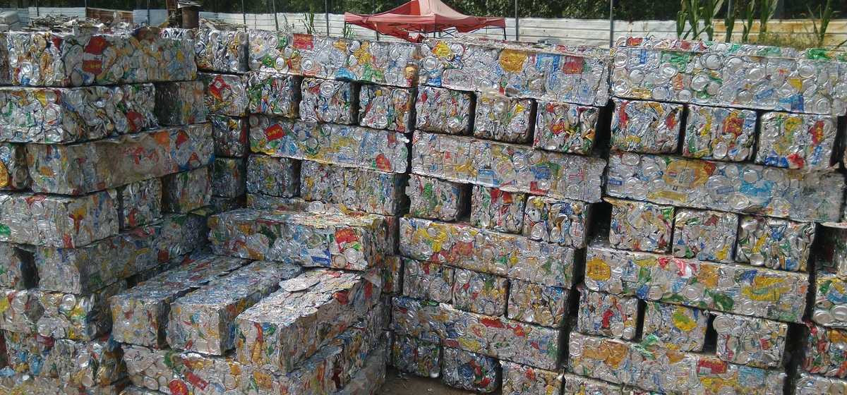Rectangular compressed beverage-can bales stacked in a recycling yard